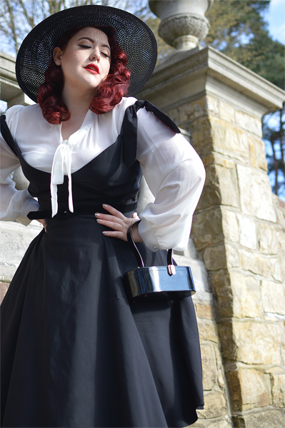 Plus size pinup Miss Amy May models the black Prairie swing dress and black cartwheel sun hat by Unique Vintage for a fit and sizing review
