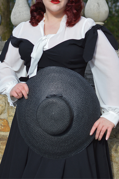 Plus size pinup Miss Amy May models the black Prairie swing dress and black cartwheel sun hat by Unique Vintage for a fit and sizing review
