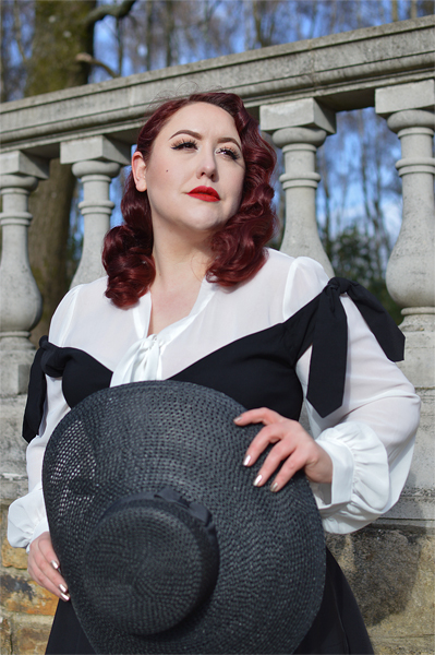 Plus size pinup Miss Amy May models the black Prairie swing dress and black cartwheel sun hat by Unique Vintage for a fit and sizing review