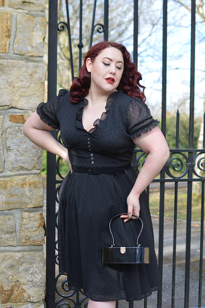 Plus size pinup Miss Amy May models the black Frilly Sundae dress gifted by Hell Bunny for a fit and size review