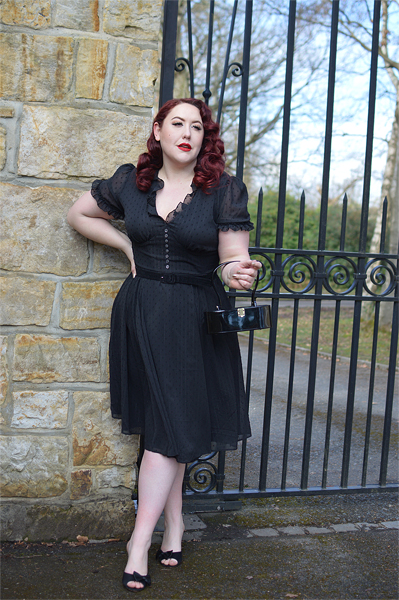 Plus size pinup Miss Amy May models the black Frilly Sundae dress gifted by Hell Bunny for a fit and size review