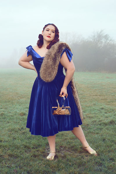 Plus size pinup Miss Amy May models the Sapphire Velvet Tilly Bow Prom swing dress by The Pretty Dress Company for a fit and size review