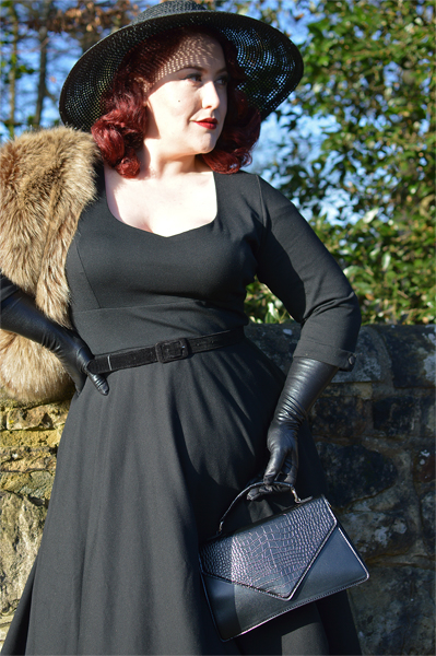 Plus size pinup Miss Amy May models the black Scarlette dress by Dolly & Dotty for a fit and sizing review