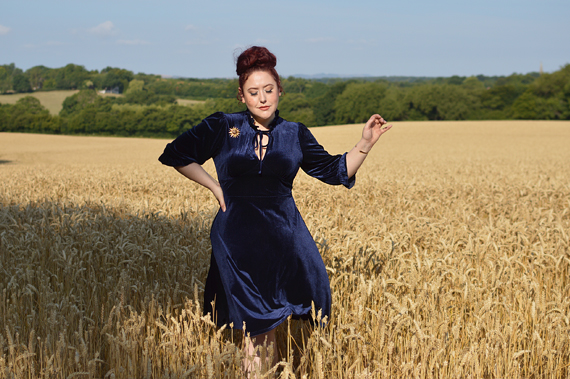 Plus size pinup Miss Amy May models the Orion navy velvet dress by Hell Bunny for a fit and size review
