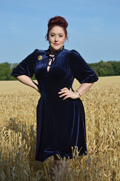 Plus size pinup Miss Amy May models the Orion navy velvet dress by Hell Bunny for a fit and size review