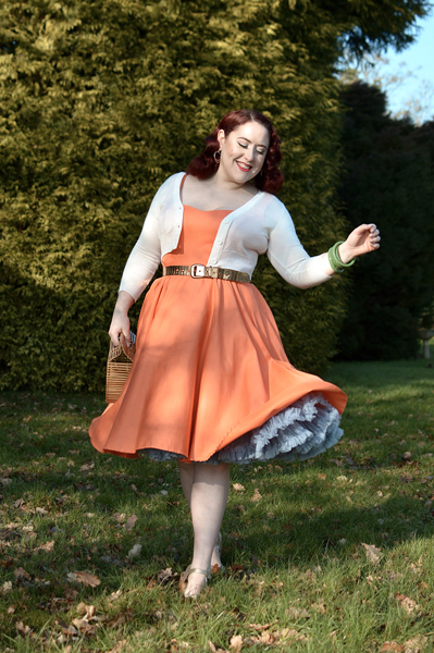 Plus size pinup Miss Amy May models the orange Heidi dress by Hell Bunny for a fit and size review