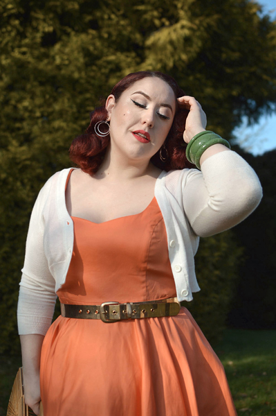 Plus size pinup Miss Amy May models the orange Heidi dress by Hell Bunny for a fit and size review